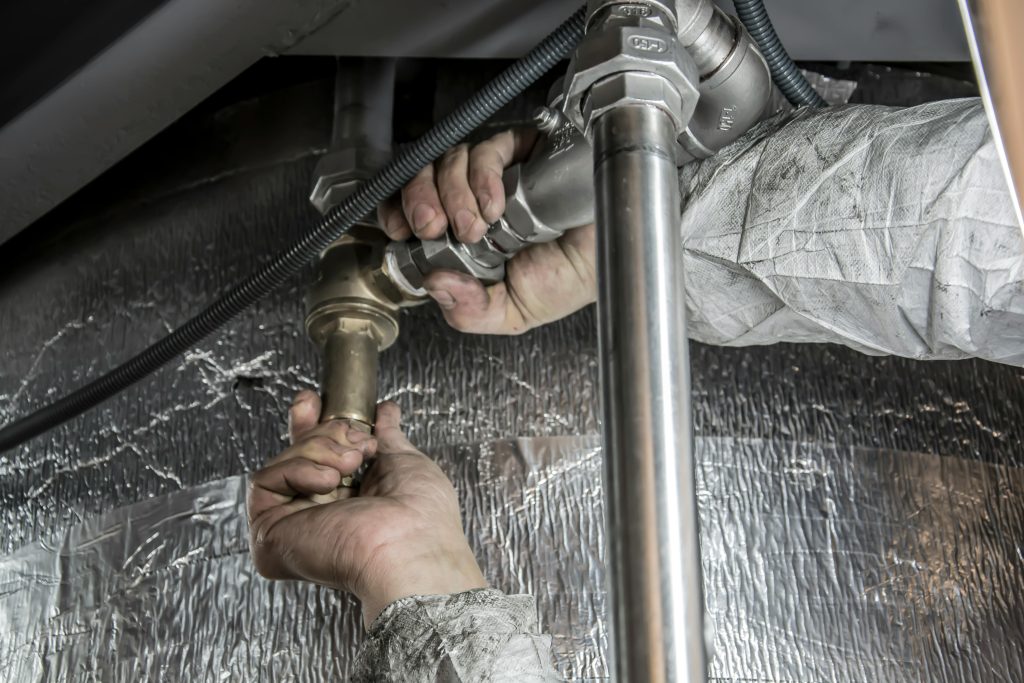 Plumber working on pipes.